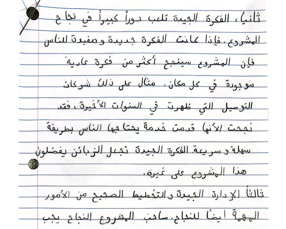 صفحة ممسوحة ضوئيًا من مقال بخط اليد بالعربية عن عوامل نجاح المشروع التجاري، مكتوب على ورق مسطّر.